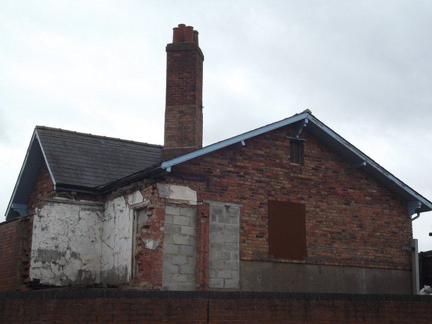 boarded up building with tall chimney