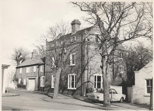 Black and white photo of Bingham manor house with trees in foreground