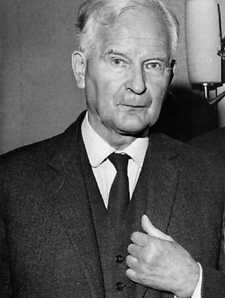 black and white photo of man in dark suit with pale hair