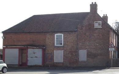 red brick house, white windows, red bus shelter in front