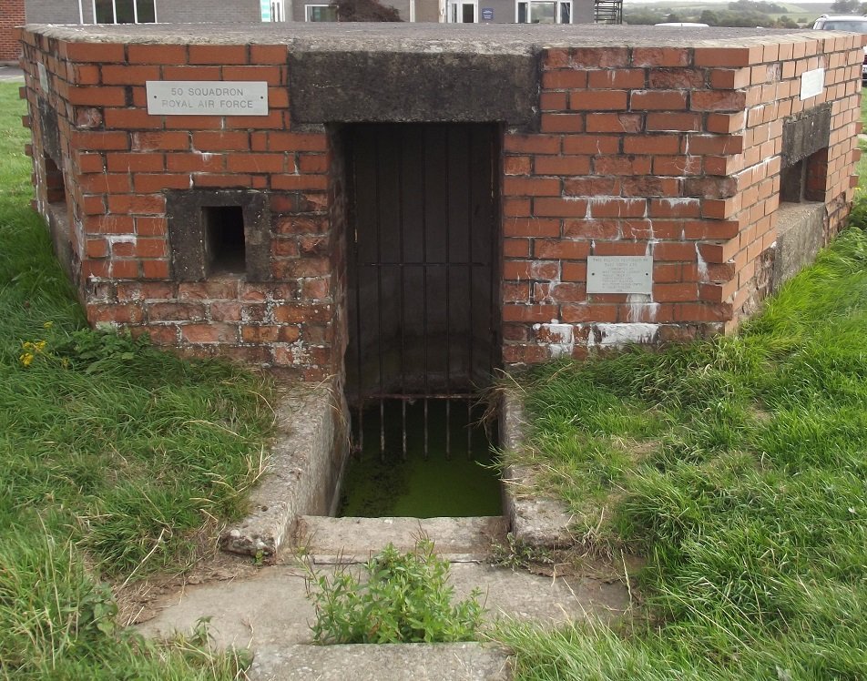 gated entrance to red brick pillbox
