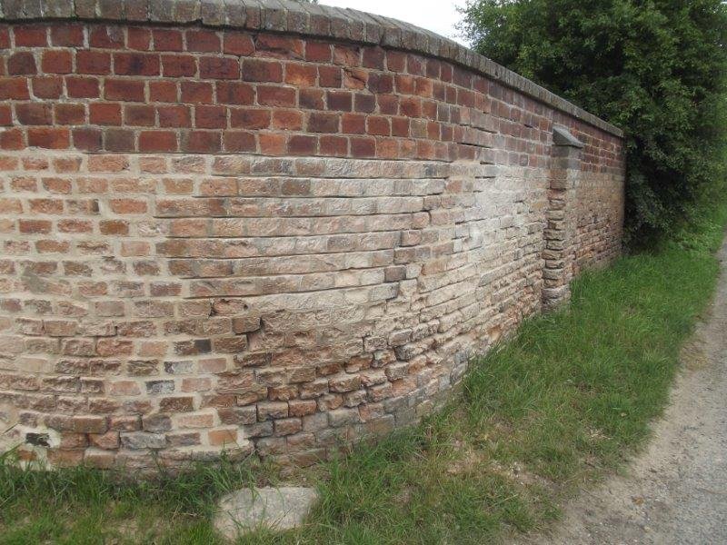 curved wall, white on bottom half, red brick at top