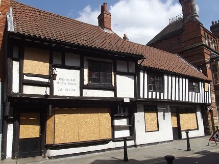 black and white building with boarded windows