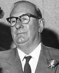 black and white photo of man in suit with glasses