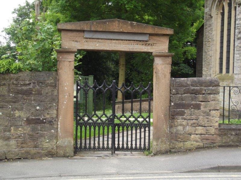 brown square stone gateway with black iron gates