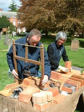 Man and woman demonstrating how to make bricks